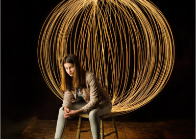 light ball; orb; light painting; painting; light; fantasy; long exposure; colors; one person; creative; girl; model; woman; light painting; paining with light; dramitic; powerful; impact; golden; night; night time; strong; beautiful; teen; teenager; 16; sweet sixteen; background; portrait; young; studio; set up; sitting; impact; powerful; confident; globe; sphere